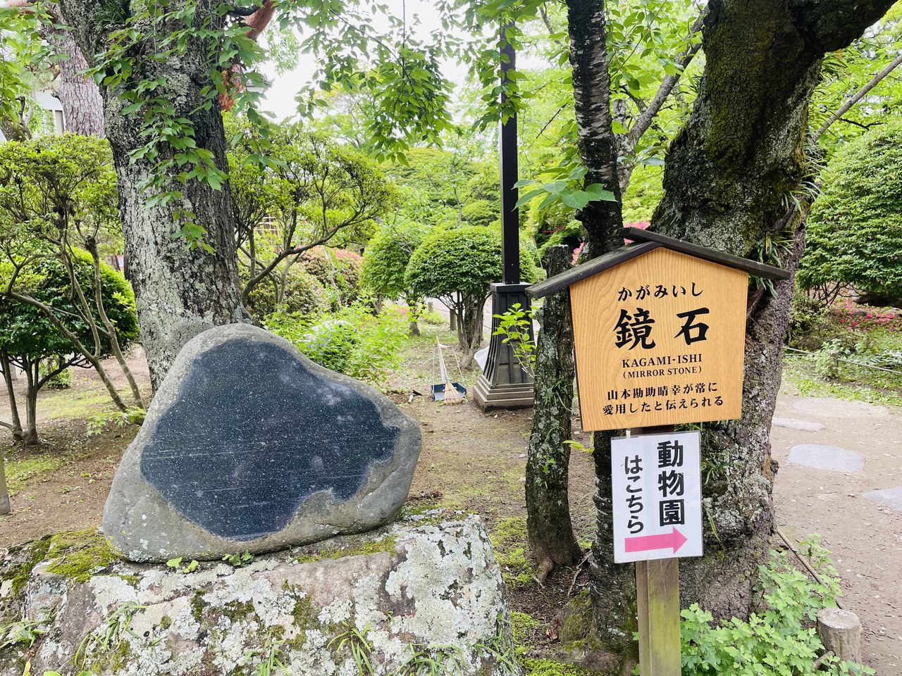 懐古園内の「鏡石」。表面がなめらかな大きな石と、由来を記した案内板