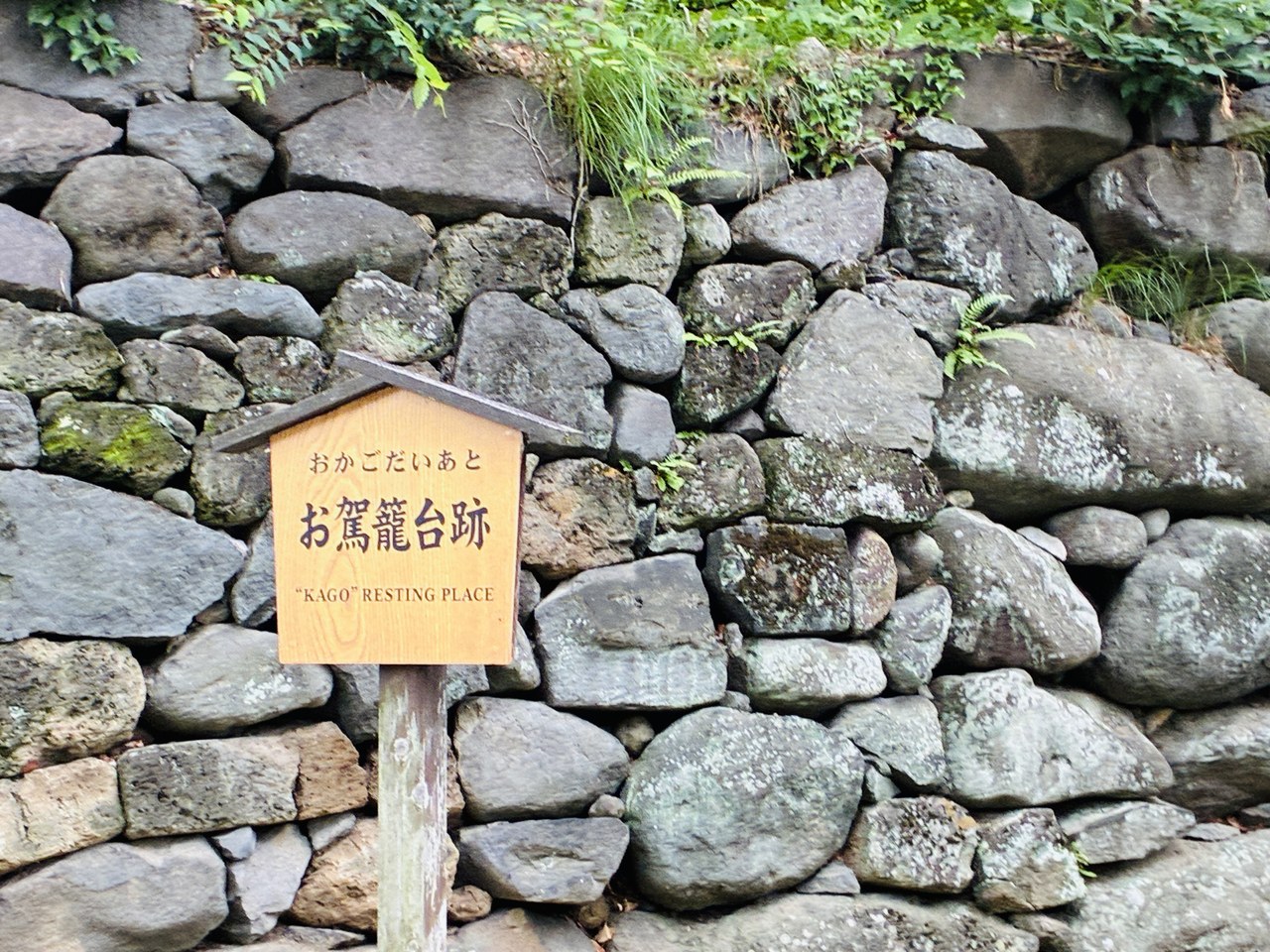 懐古園内の「お駕籠台跡」の案内板と野面積みの石垣
