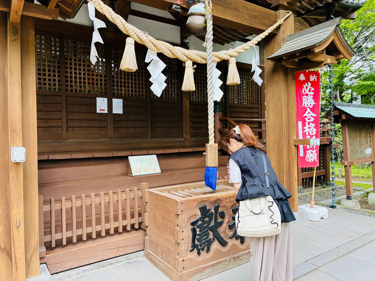 懐古神社の社殿前で、「必勝合格祈願」ののぼりのそばで参拝する様子