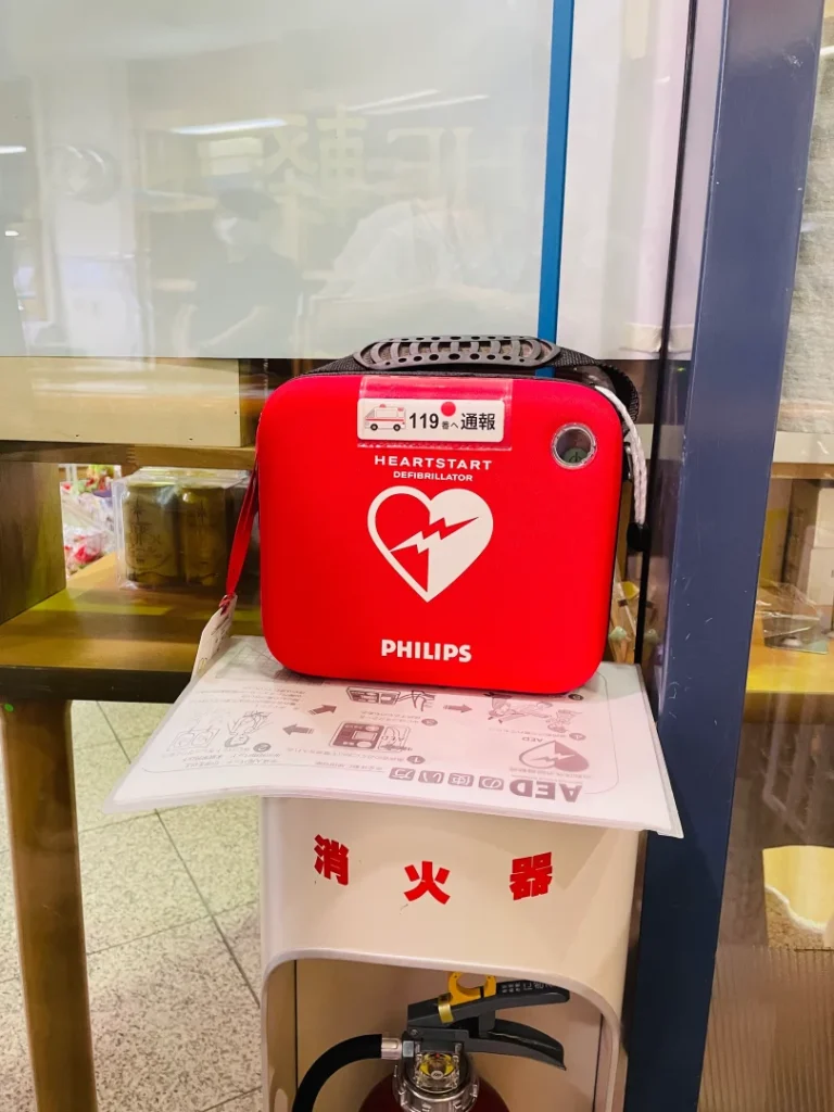 プラザ佐久に設置されたPHILIPS製の赤いソフトケース入りAED。消火器の上にある