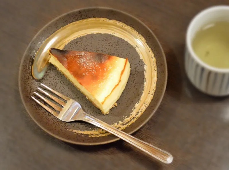 郷ごころのチーズケーキ。こんがり焼き色のついたベイクドチーズケーキが和の器に盛られ、お茶が添えられている