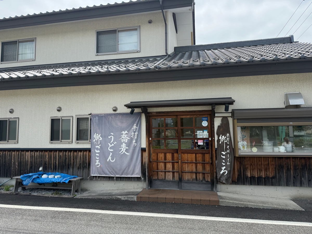 小海線・三岡駅前にある「手打ちそば うどん 郷ごころ」の外観。「手打ち 蕎麦 うどん 郷ごころ」と書かれたのれんが目印