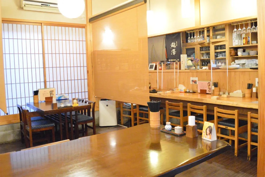 郷ごころの店内。カウンター席とテーブル席が並ぶ、木の温もりを感じる落ち着いた空間