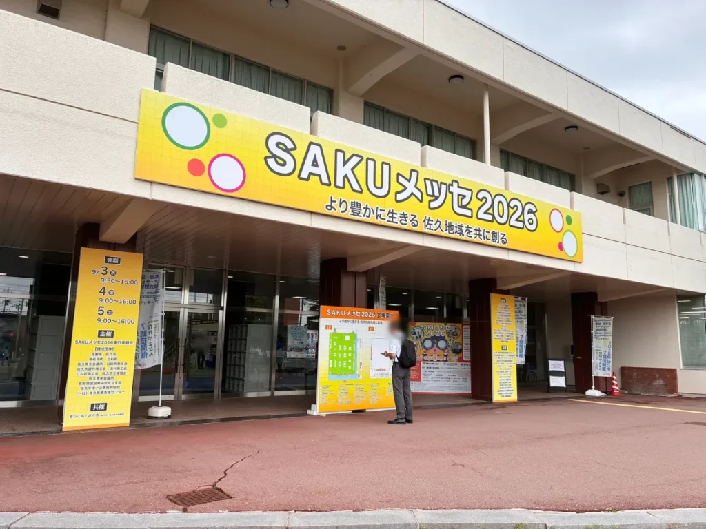 佐久市総合体育館の入口に掲げられた「SAKUメッセ2026」の看板と会期の案内