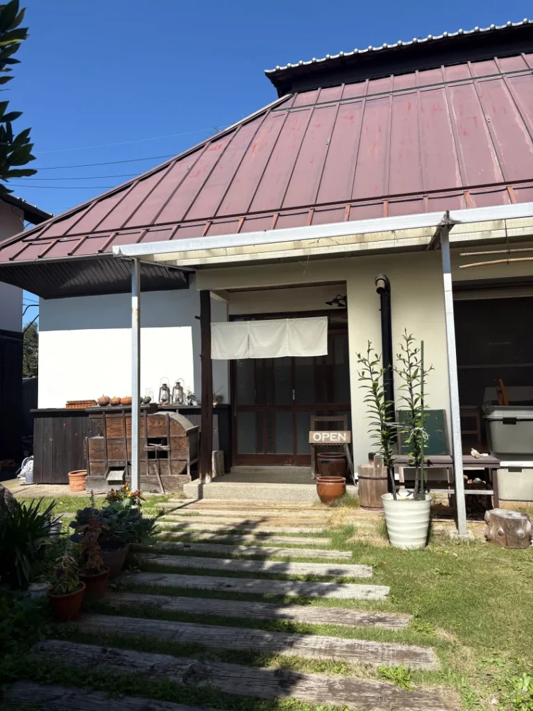 青空の下に建つ、小諸市八満の古民家カフェ農カフェわのんの外観